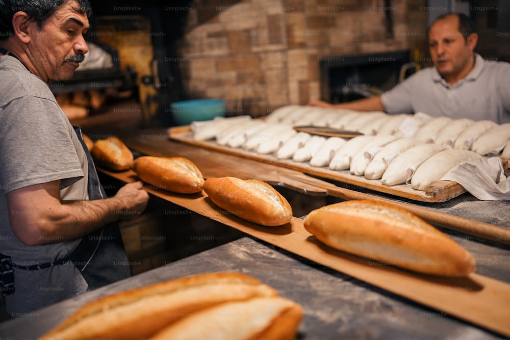 two men working in a bakery making bread