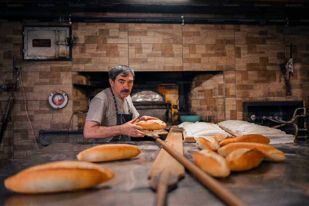 Un hombre está haciendo pan en una panadería