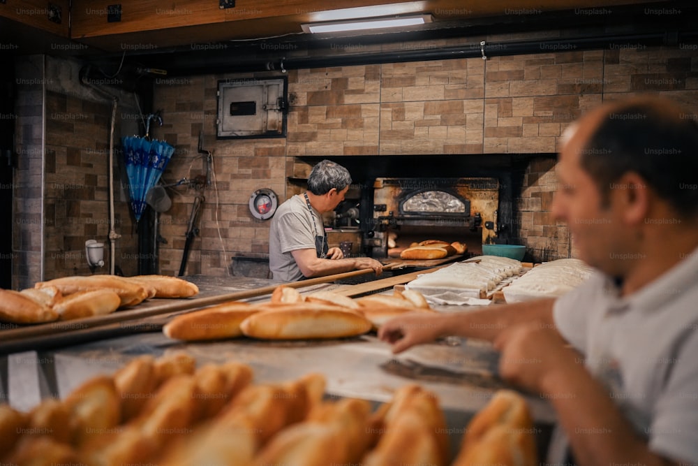 Due uomini che lavorano in una panetteria che fa il pane