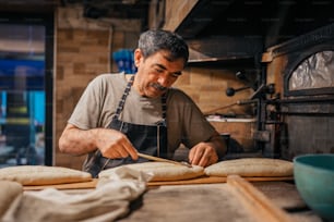 a man in an apron making bread in a kitchen