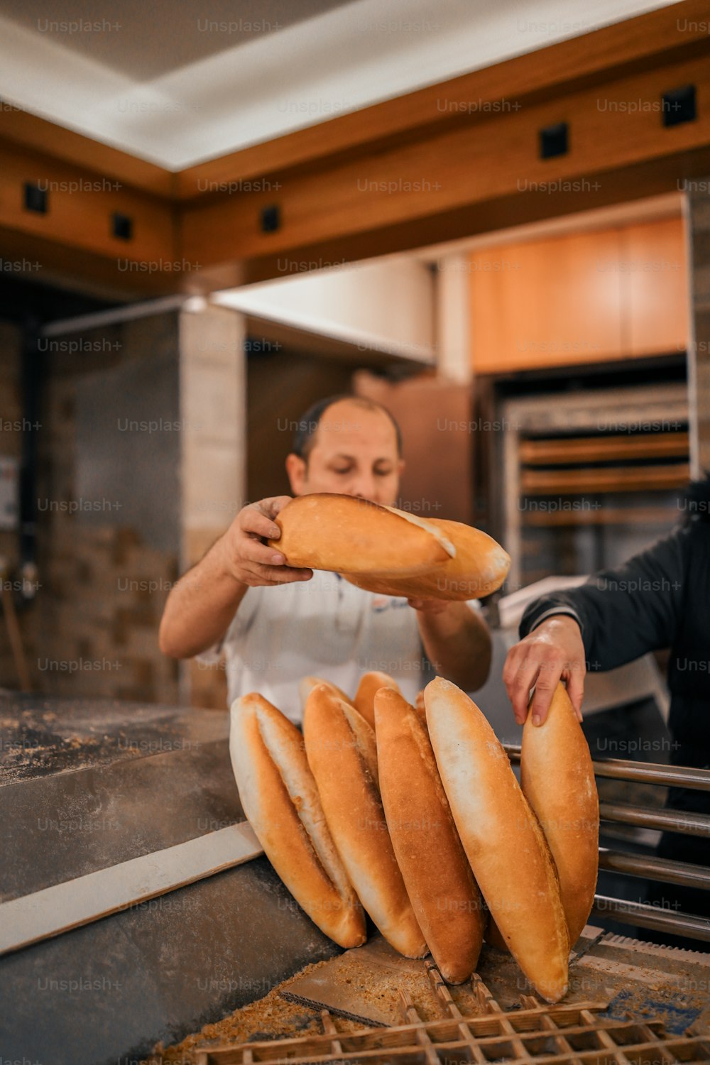 um homem em uma cozinha colocando pão em uma prateleira