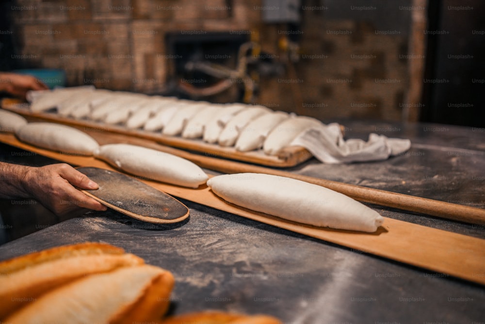 Un hombre está haciendo pan en una panadería