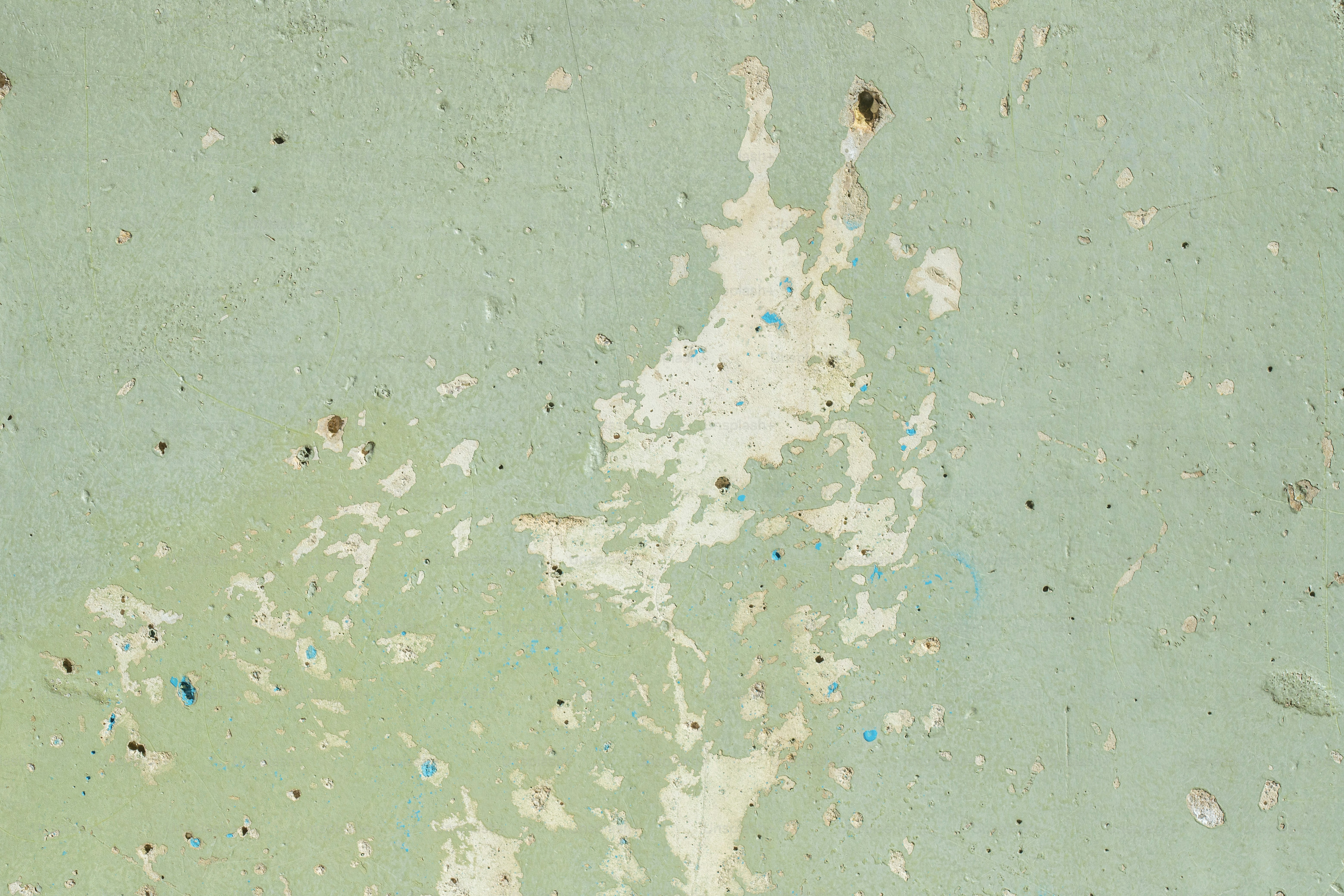 eine grüne Wand mit abblätternder Farbe darauf