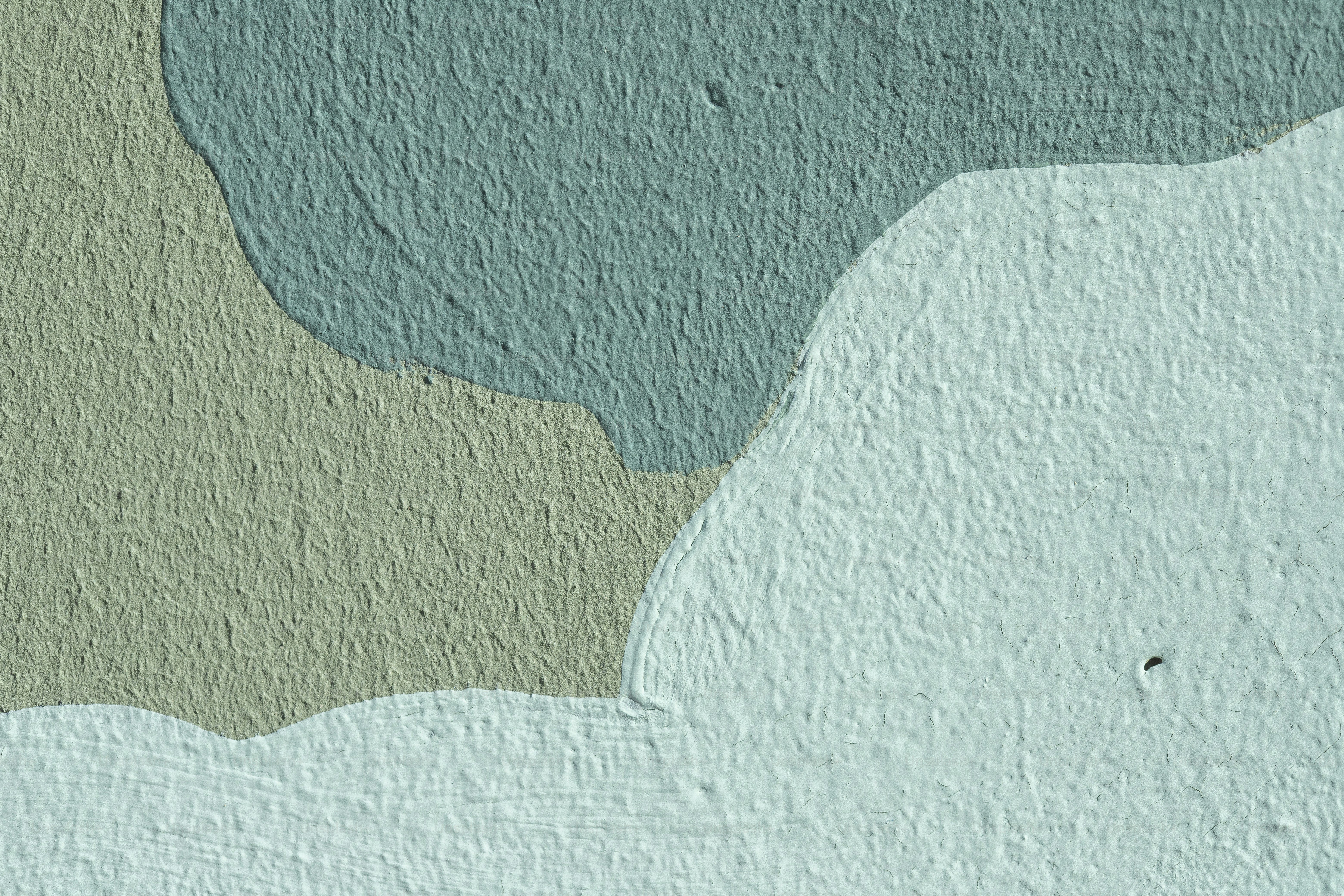 a blue and green painted wall with a bird on it