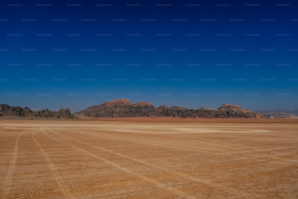 a large open field with mountains in the background