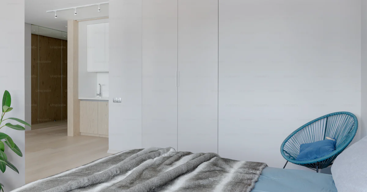Foto Un dormitorio con una cama y una silla – Muebles Imagen en Unsplash