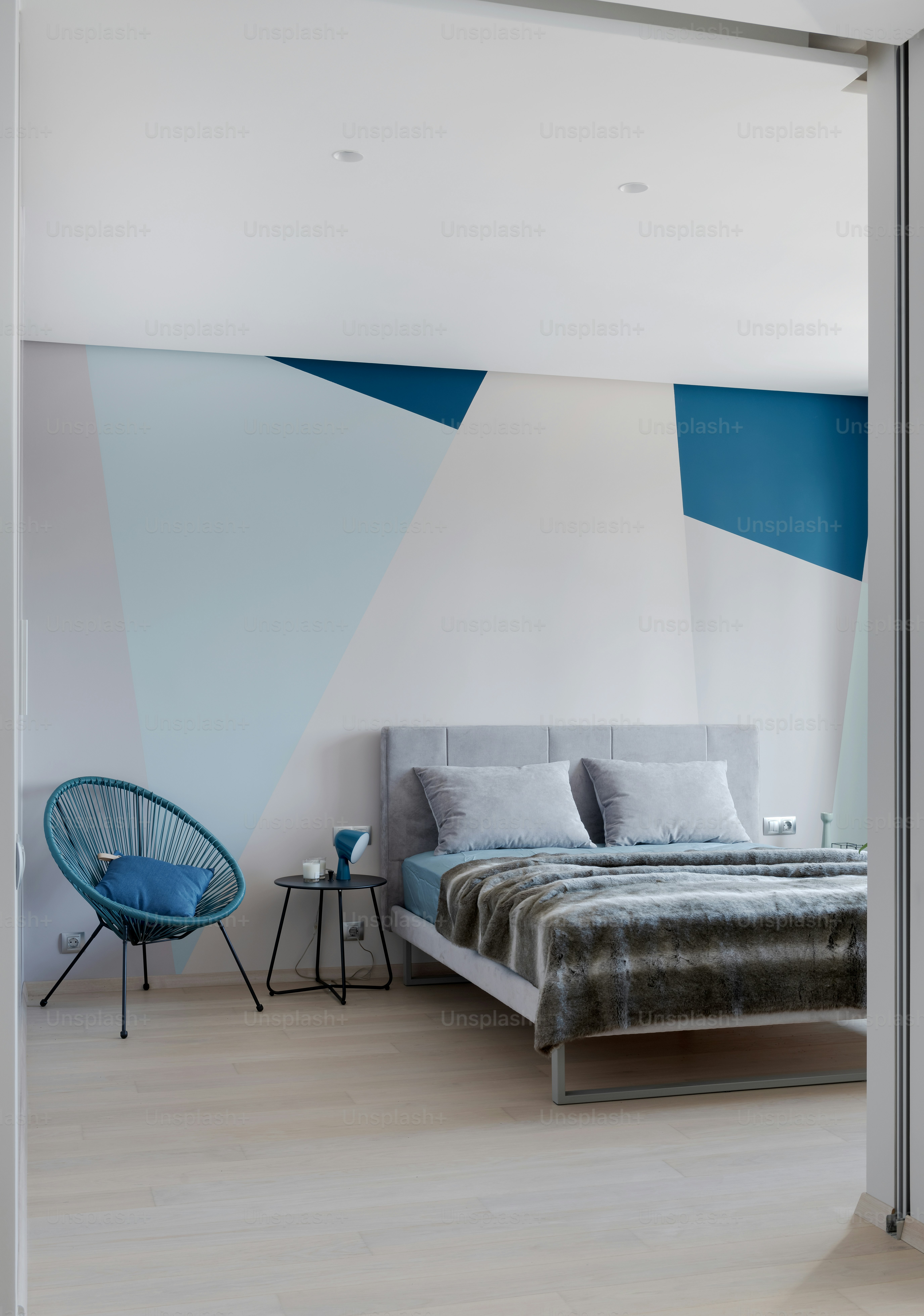 a bed sitting in a bedroom next to a blue chair