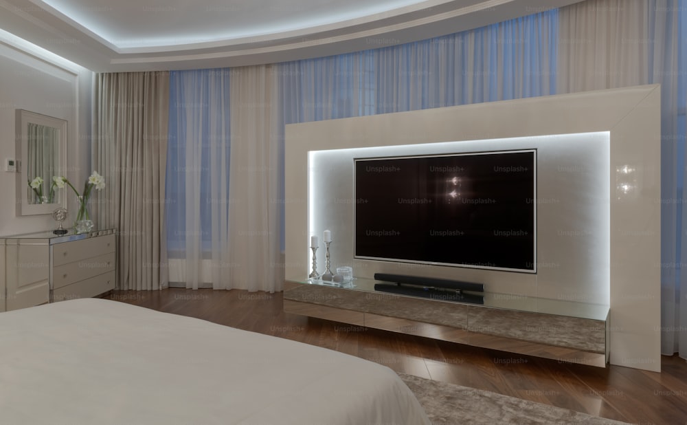 Un dormitorio con un gran televisor de pantalla plana en la pared