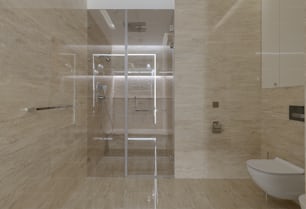 une salle de bain avec une porte de douche en verre et des toilettes