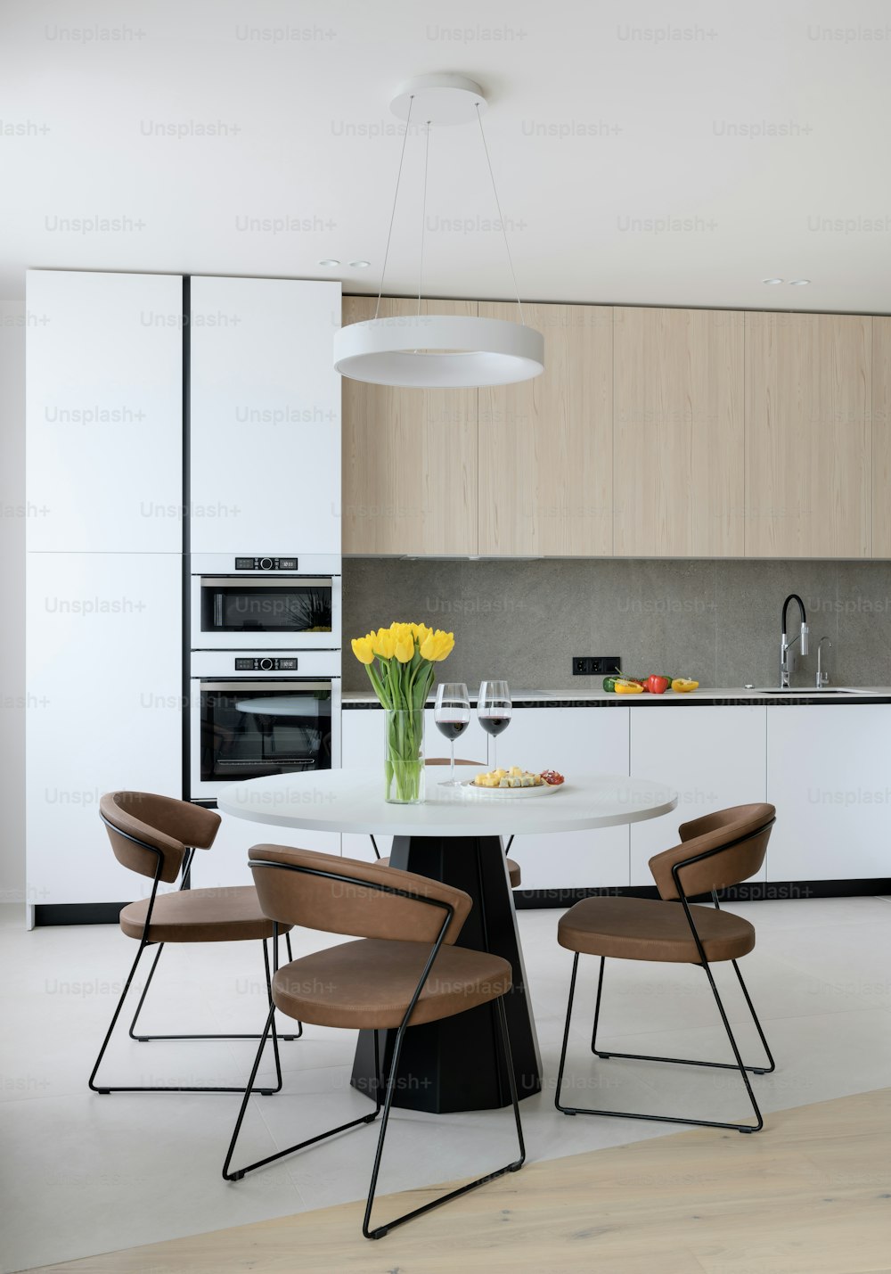 uma cozinha com uma mesa, cadeiras e um vaso de flores