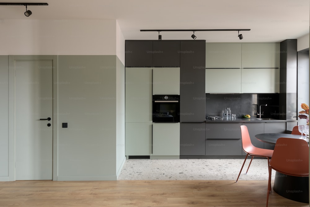 a kitchen area with a table, chairs, and cabinets