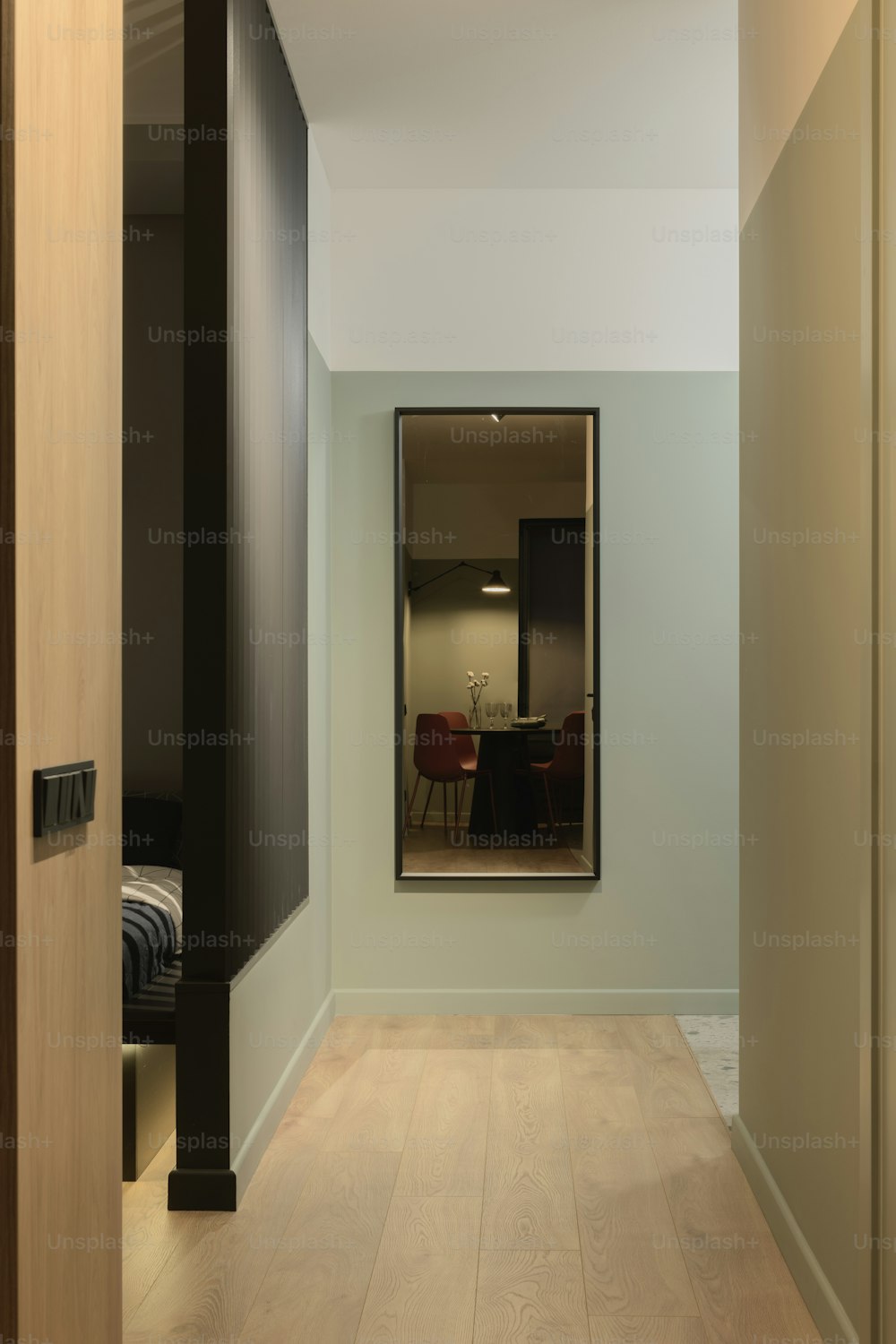 un corridoio con uno specchio e un pavimento in legno