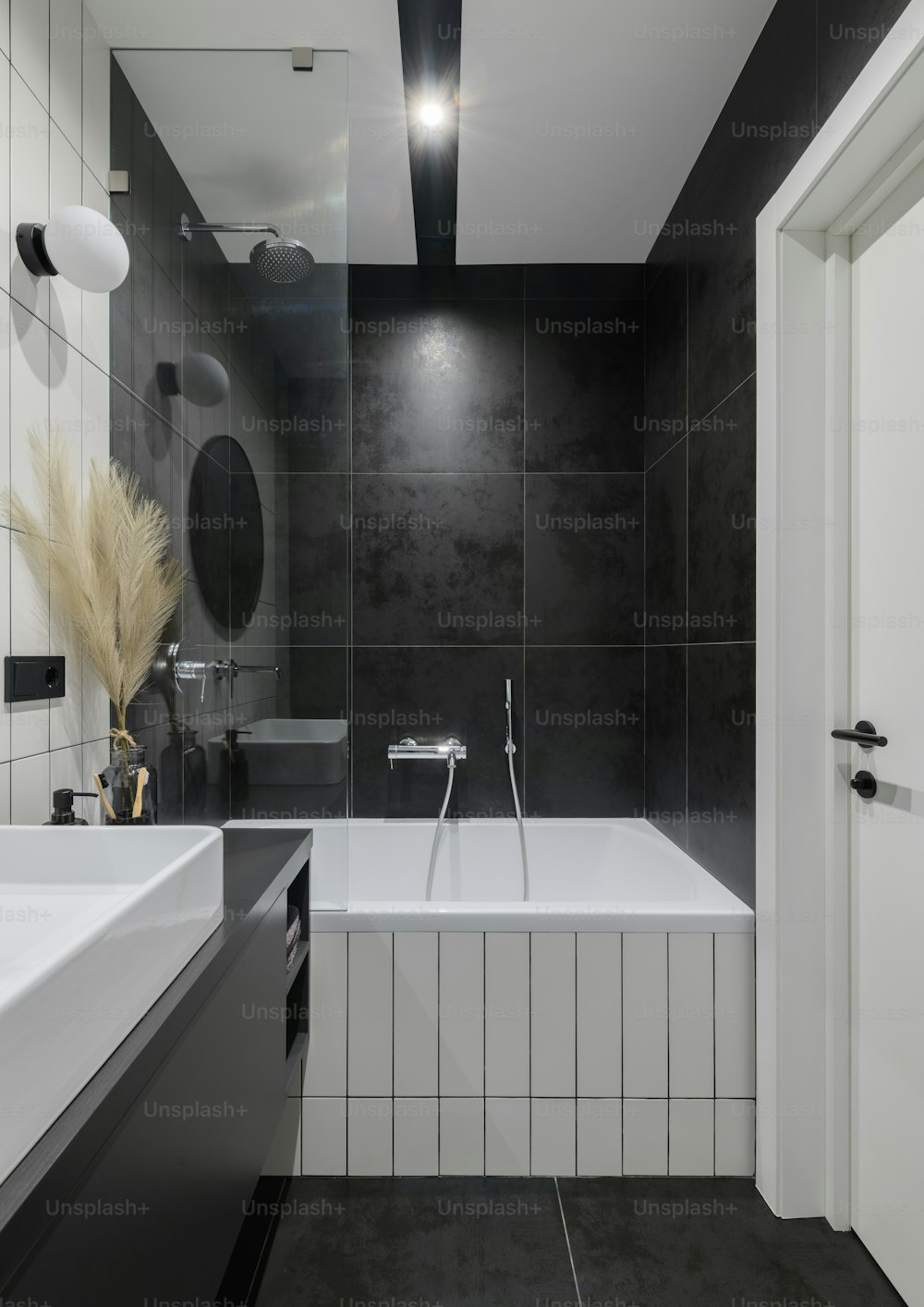 a black and white bathroom with a bathtub and sink