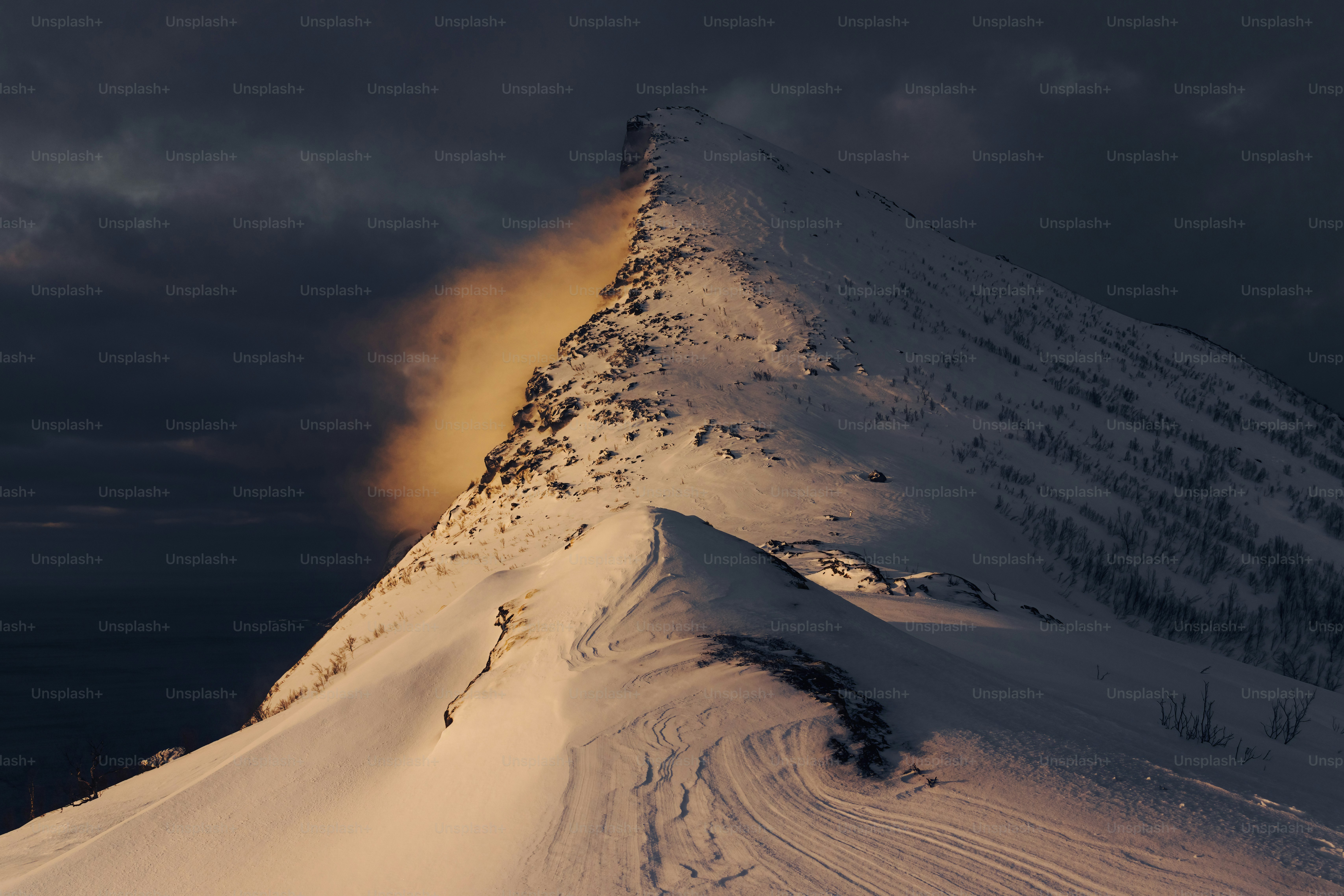 a snow covered mountain under a cloudy sky