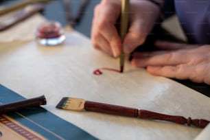 a person writing on a piece of paper with a pen