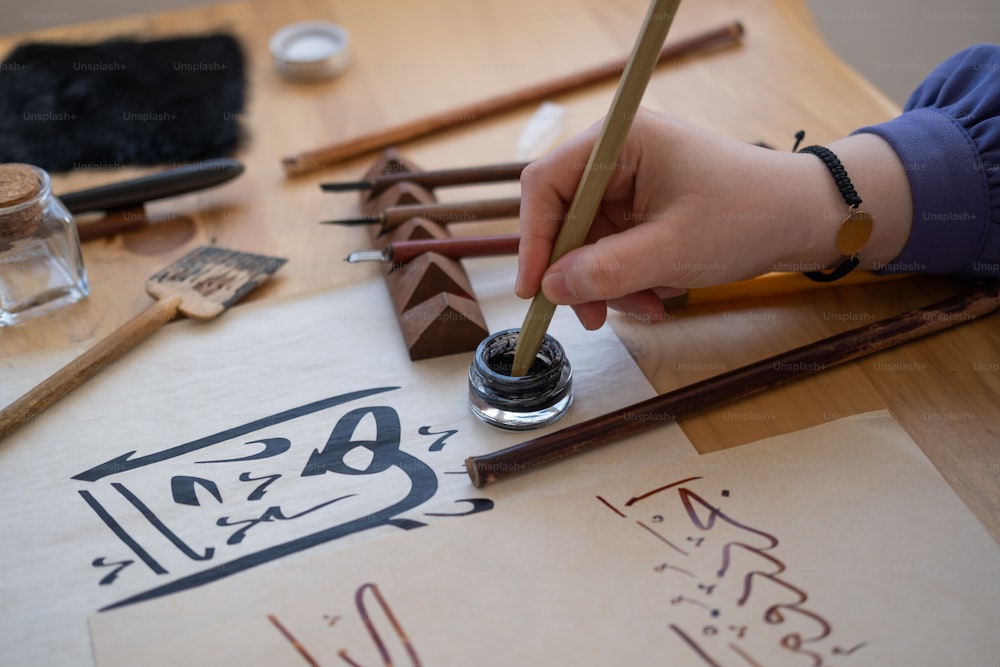 eine Person, die mit einem Bleistift auf ein Blatt Papier schreibt