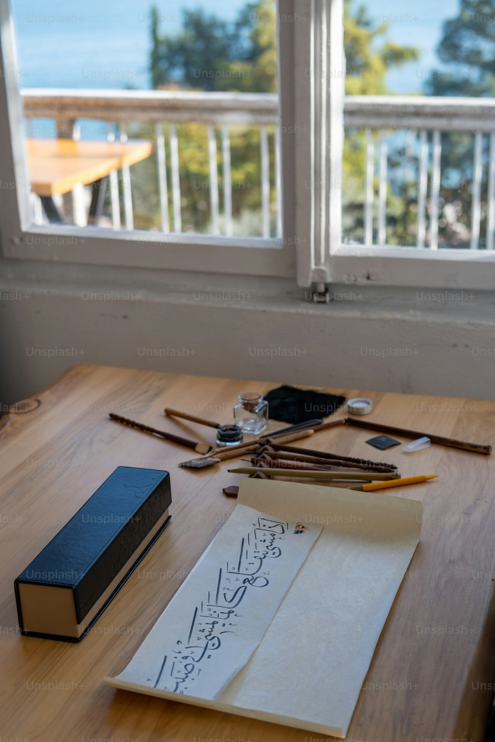 a wooden table topped with a book and a window