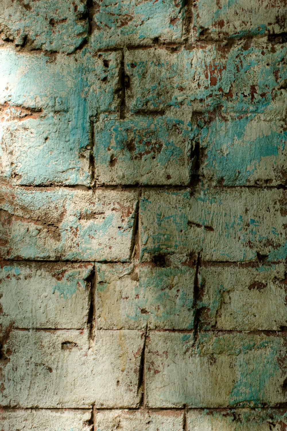a close up of a brick wall with peeling paint
