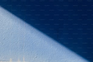 uma parede azul com uma sombra de um relógio sobre ela