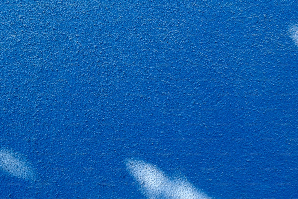 the shadow of two people on a blue wall