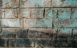 un mur de briques avec une peinture rouge et bleue dessus