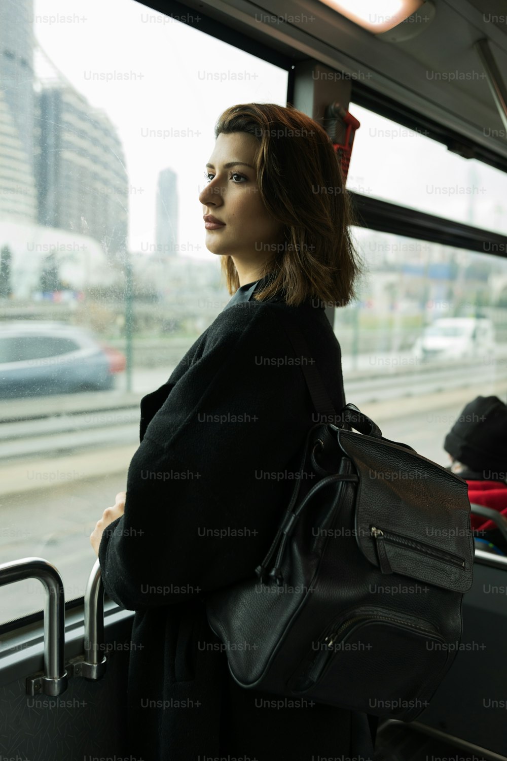 a woman standing on a bus looking out the window