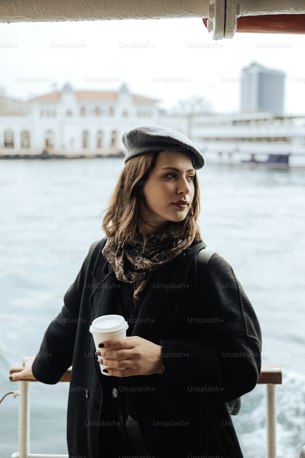 uma mulher em pé em um barco segurando uma xícara de café