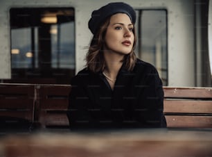帽子をかぶってベンチに座っている女性