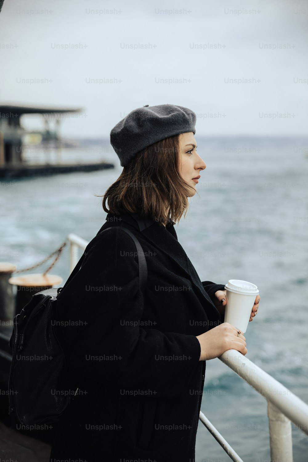 커피 한 잔을 들고 보트에 서 있는 여자