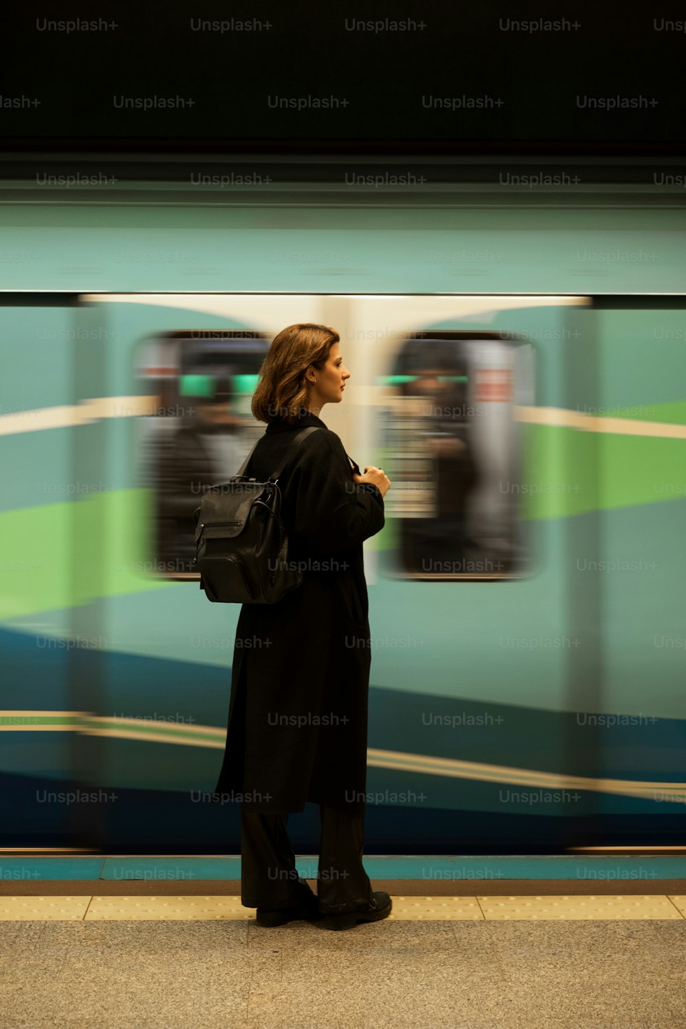 Une femme attend un train dans une gare