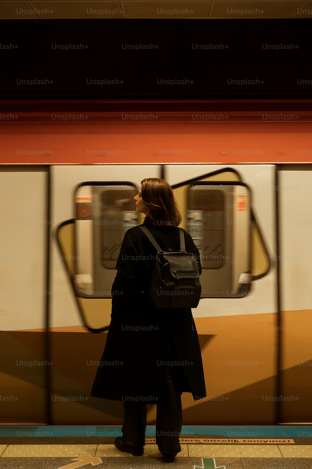 a woman waiting for a train at a subway station