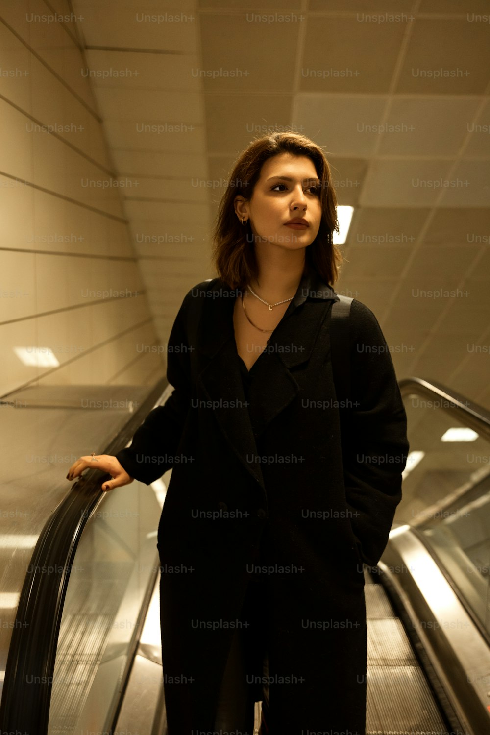a woman standing on an escalator in a building
