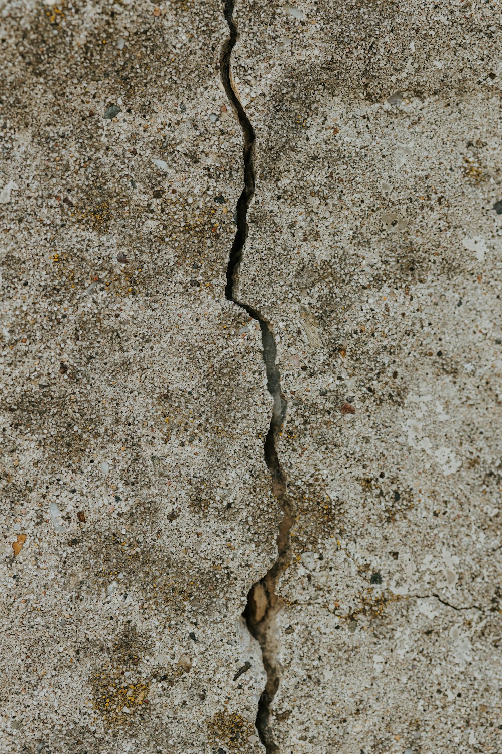 uma rachadura em uma parede de concreto com um sinal de parada sobre ela