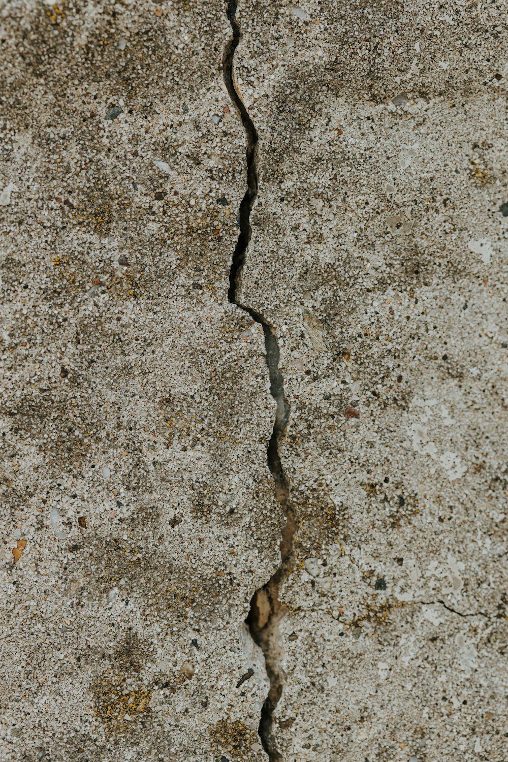 a crack in a concrete wall with a stop sign on it