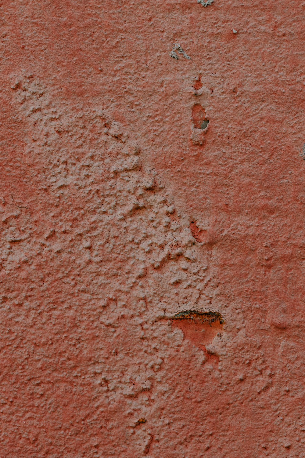 a close up of a red wall with small holes in it