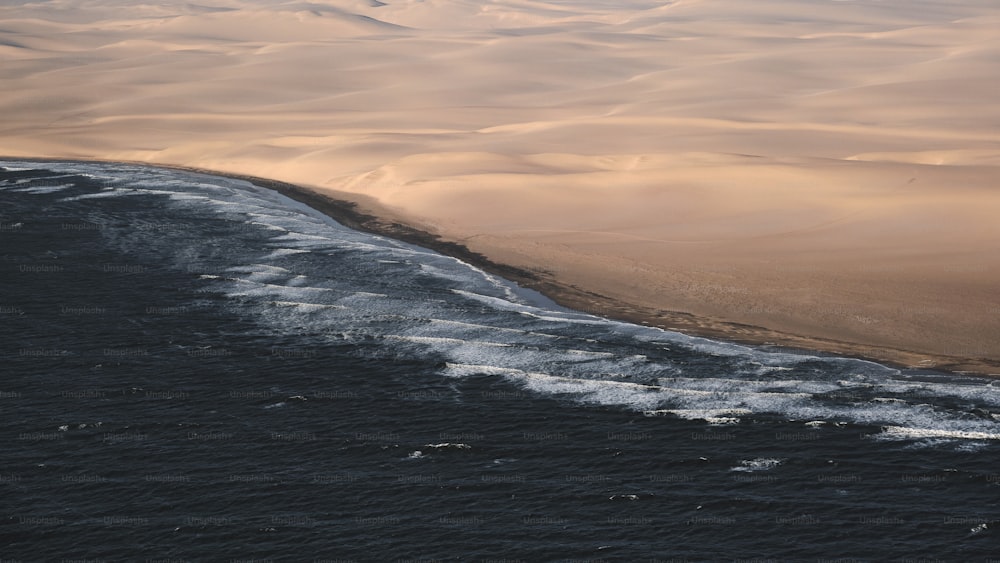 a large body of water surrounded by sand dunes