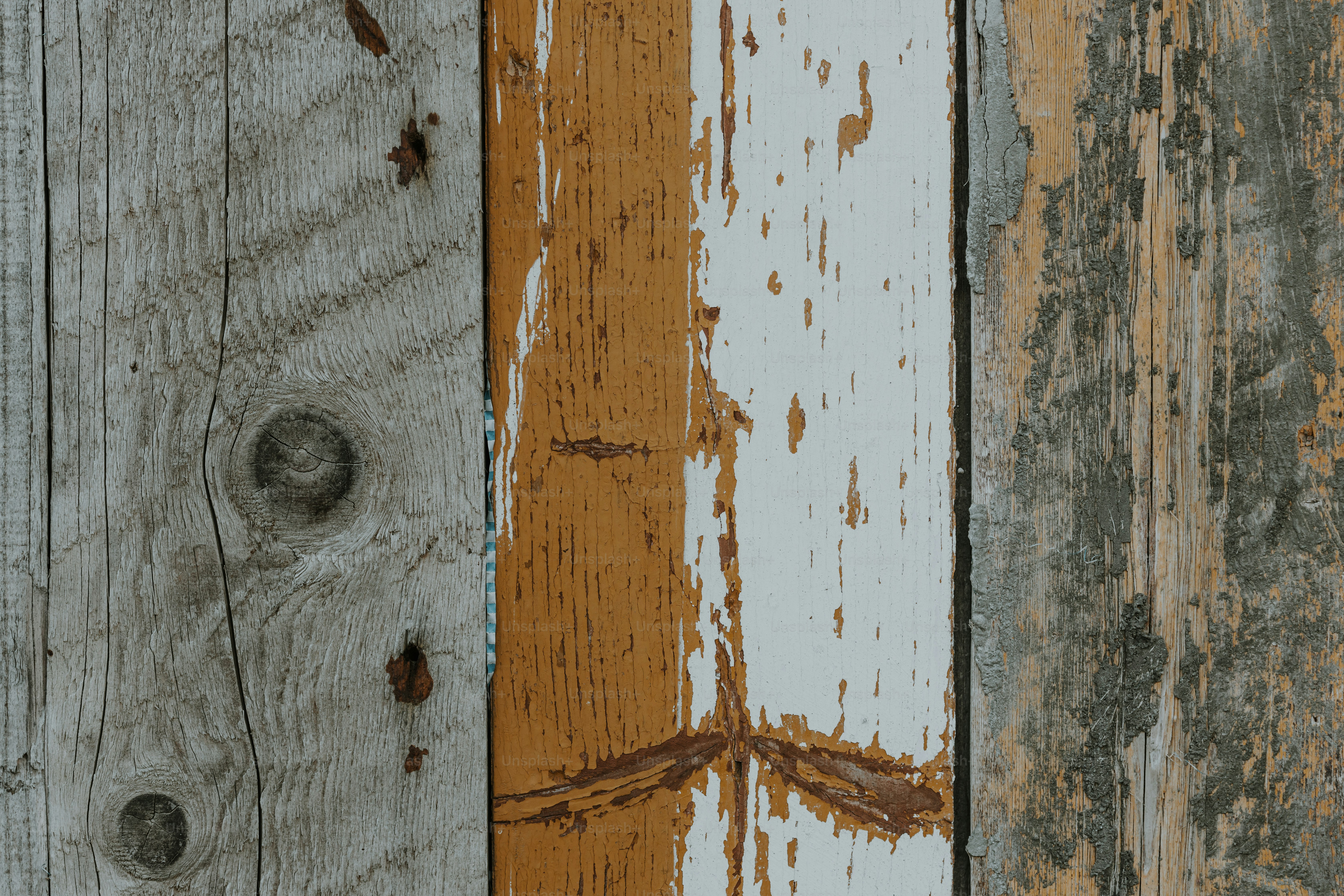 a close up of a wooden wall with peeling paint