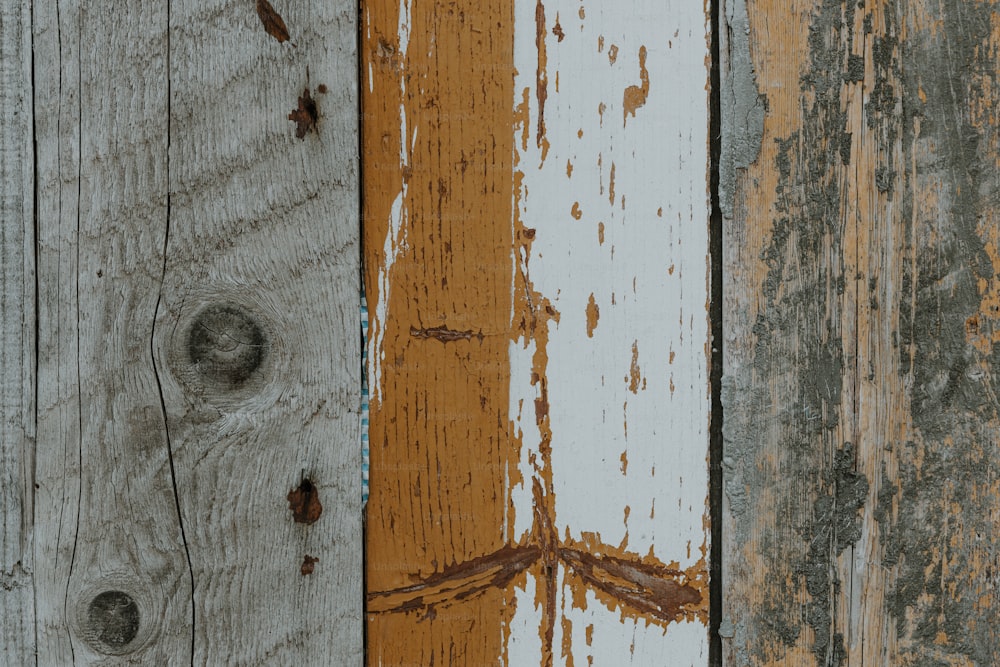 Un primo piano di una parete di legno con vernice scrostata