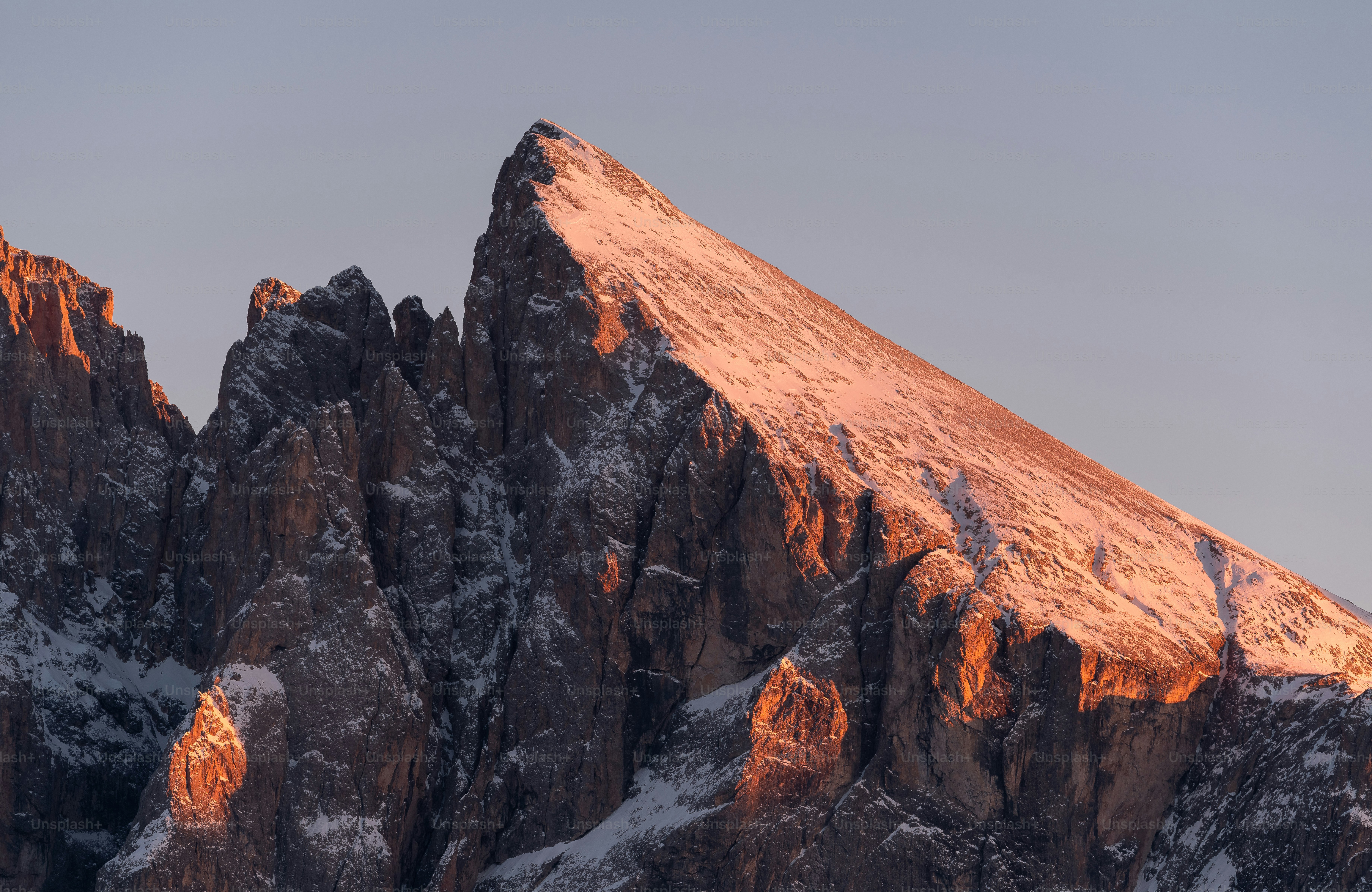 una montaña muy alta cubierta de nieve bajo un cielo azul
