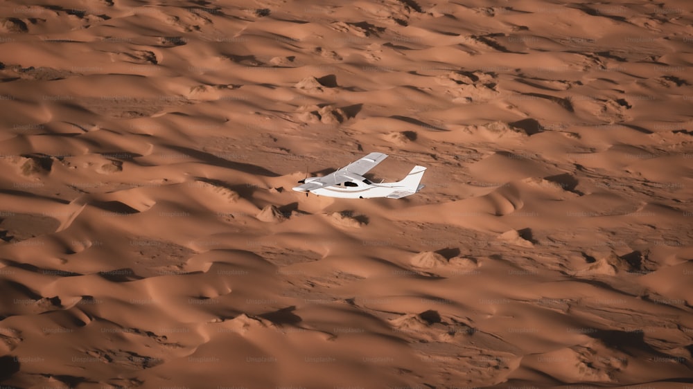 a small white airplane sitting in the middle of a desert