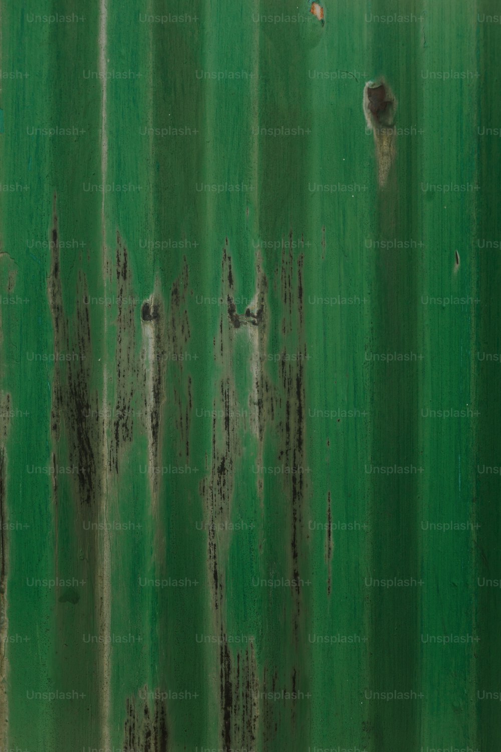 a rusted metal surface with green paint
