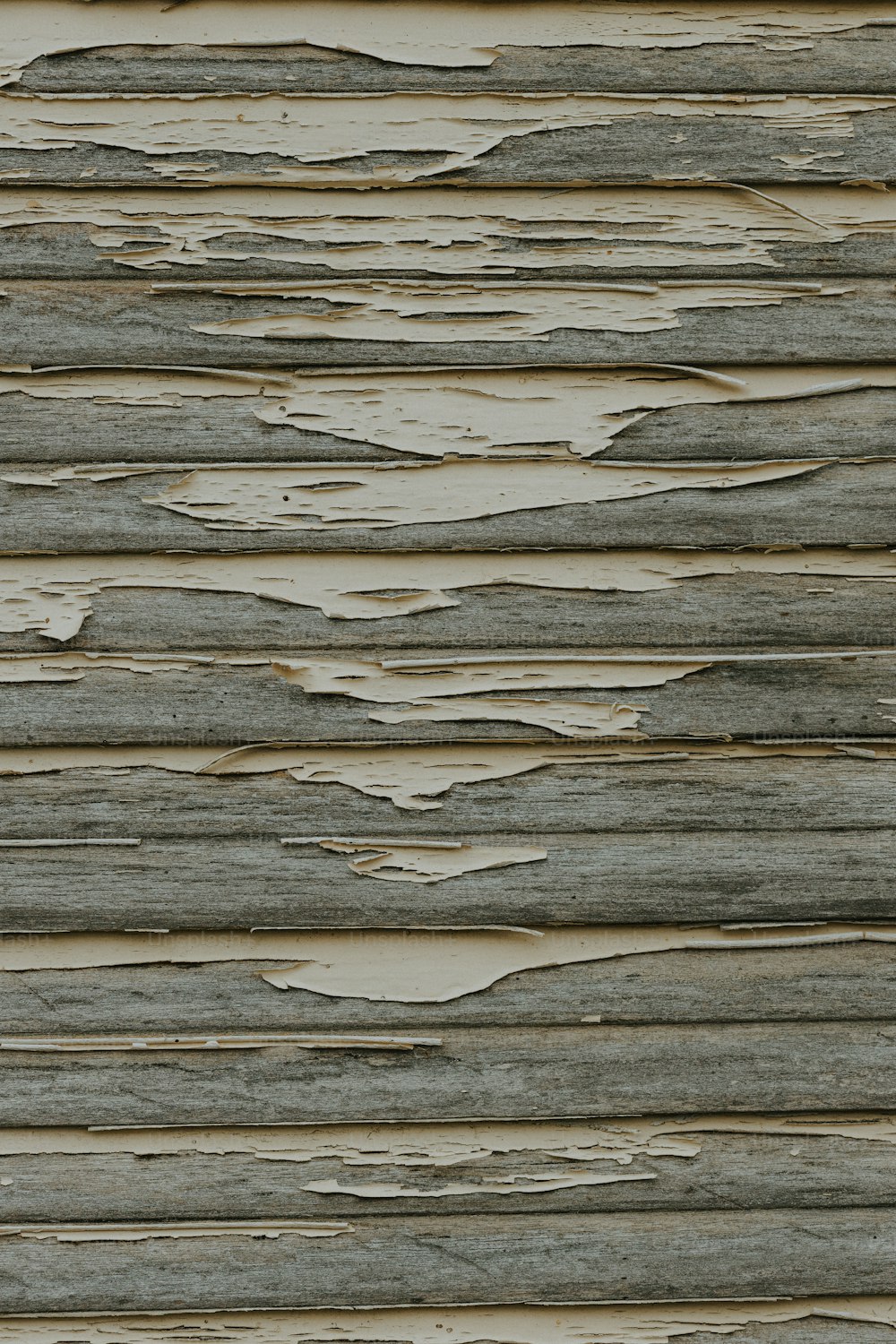 Un primo piano di una parete di legno con vernice scrostata