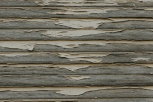 a close up of a wooden wall with peeling paint