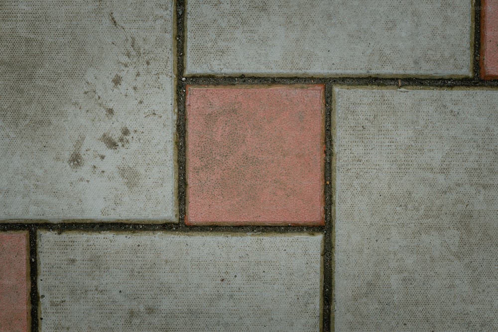 Un primo piano di un pavimento piastrellato con piastrelle rosse e bianche