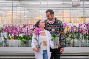 a man and a woman standing next to each other in a greenhouse