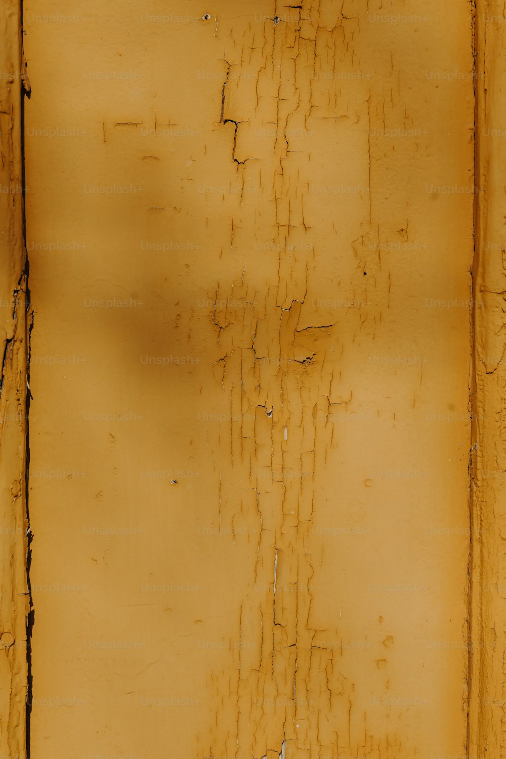 uma parede amarela com tinta descascando sobre ela