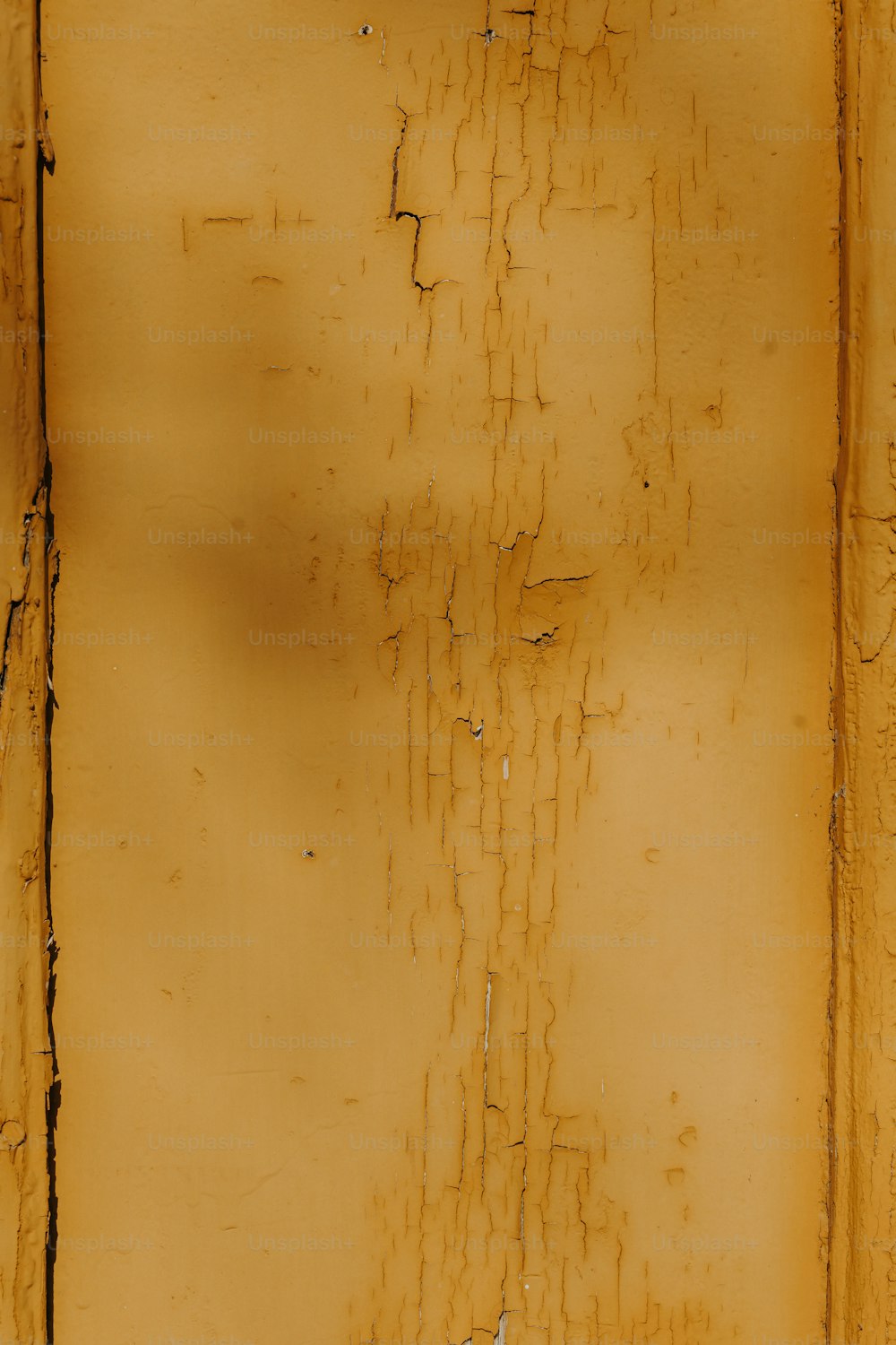 a yellow wall with peeling paint on it