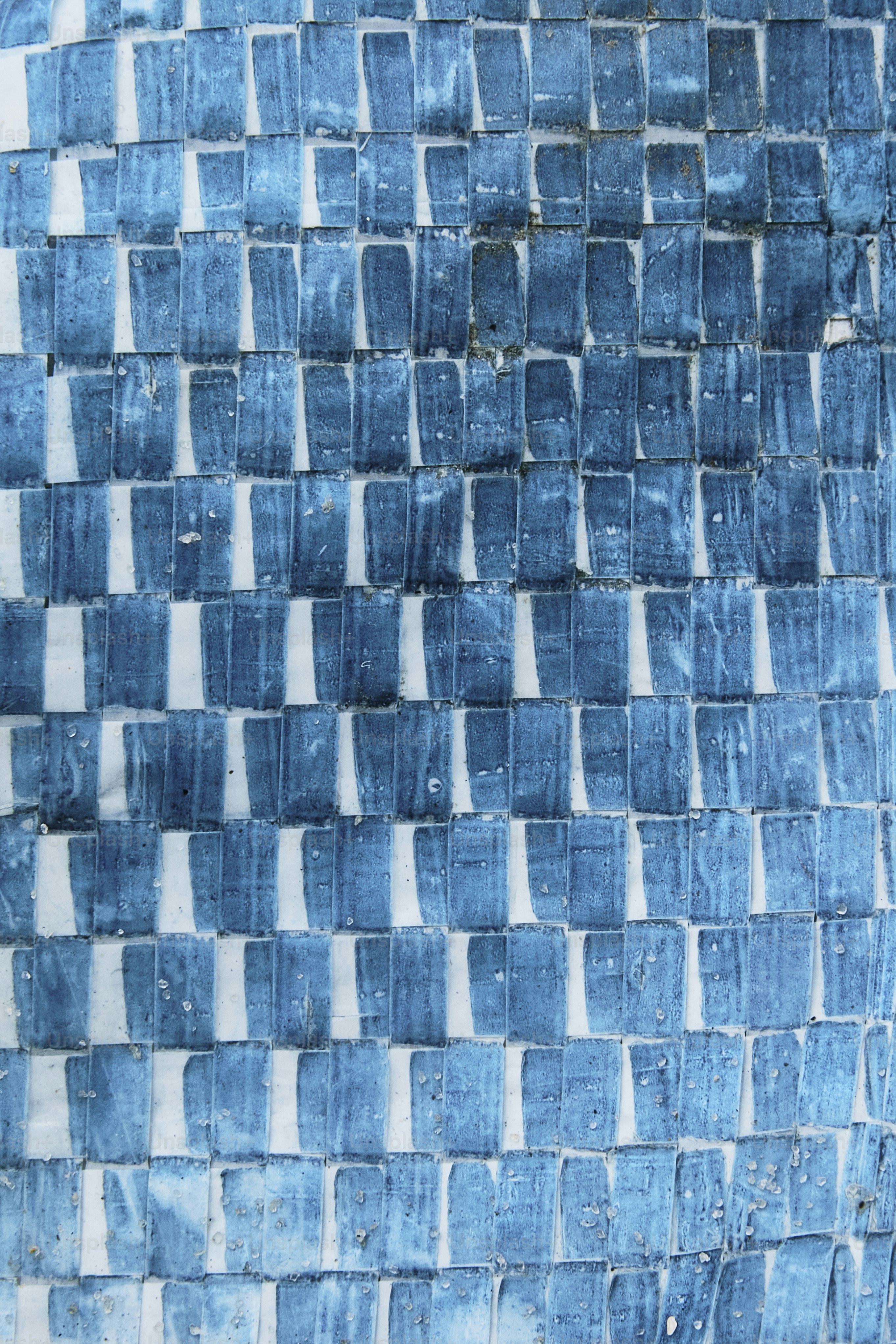 un mur carrelé bleu et blanc avec une horloge dessus