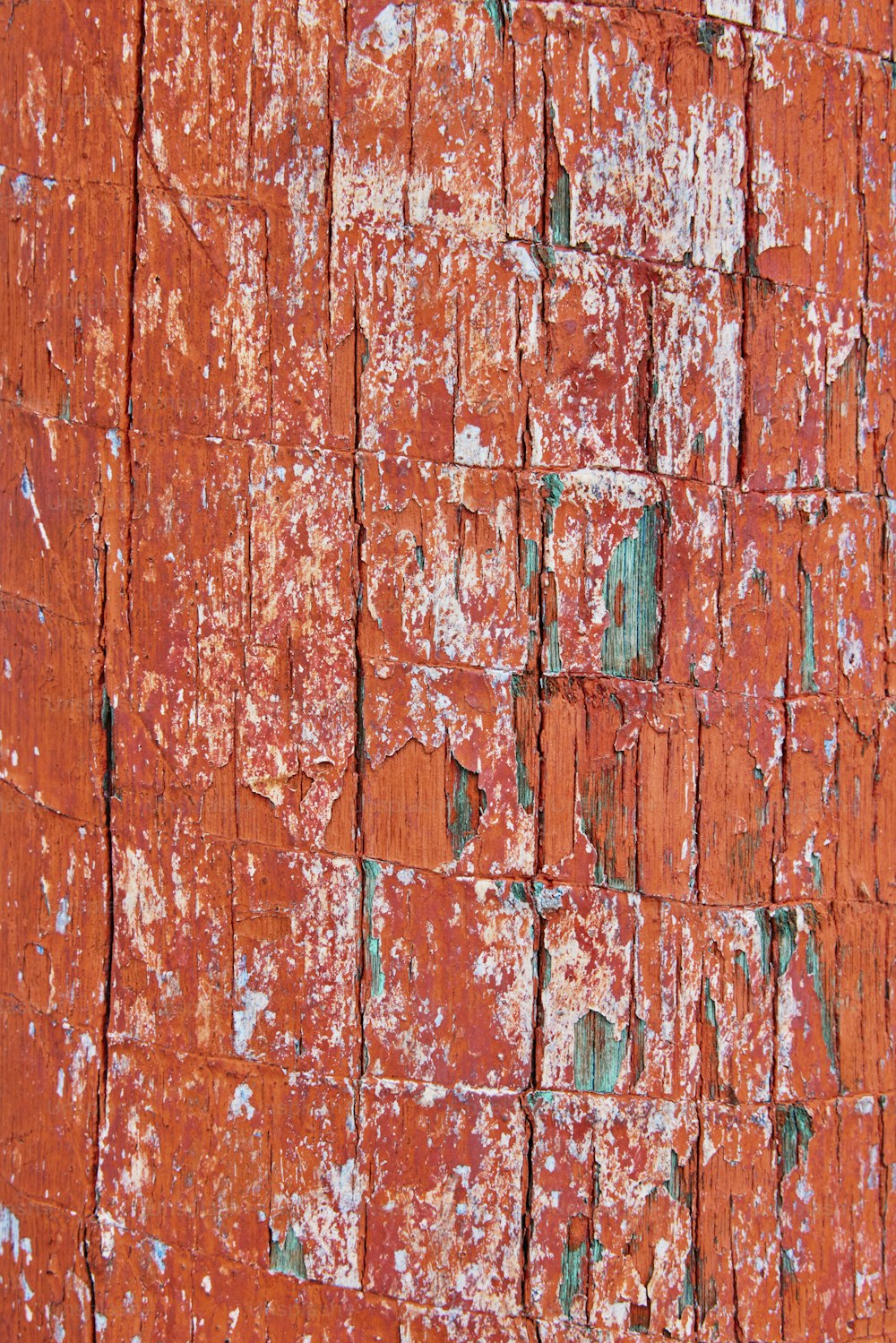 a close up of an orange wall with peeling paint