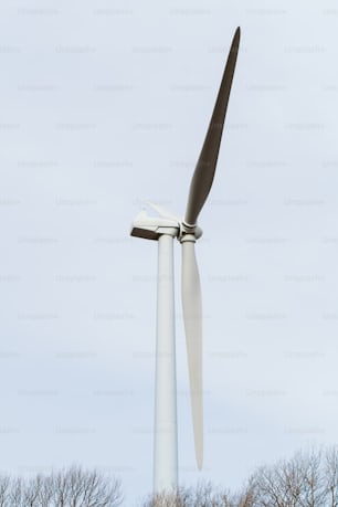 a wind turbine in a field with trees in the background